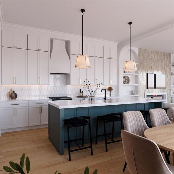 Kitchen with white cabinets, crown molding, decorative light fixtures, light wood-style floors, and a center island with sink