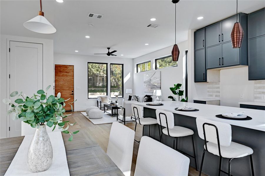 Kitchen featuring a kitchen bar, decorative light fixtures, recessed lighting, wood finished floors, and tasteful backsplash