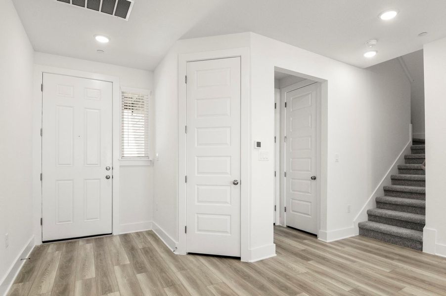 Foyer featuring stairway, light wood-type flooring, and recessed lighting