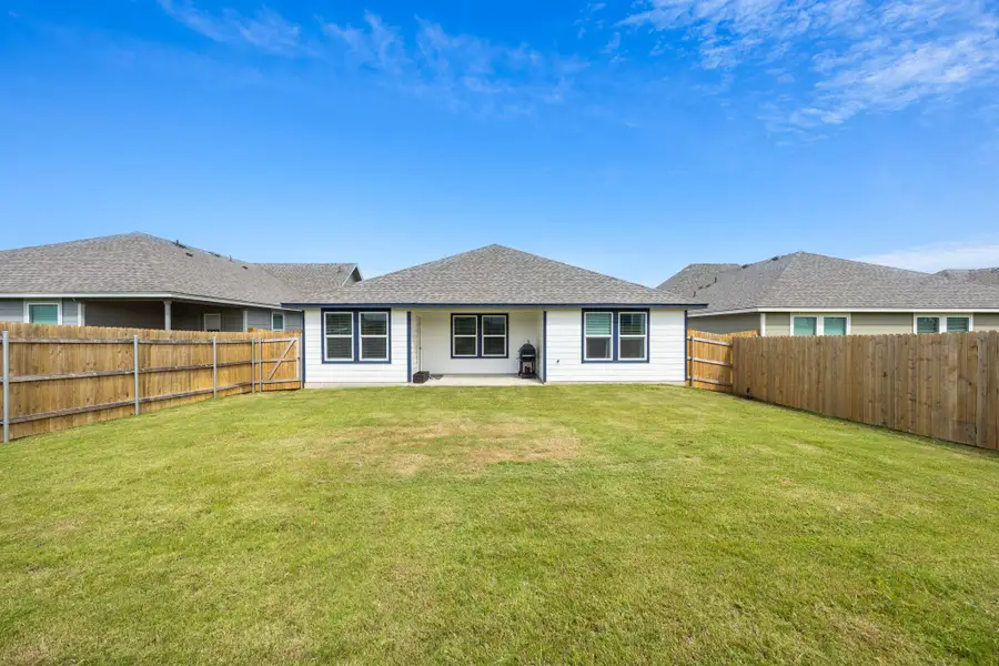 A generous backyard provides ample space for outdoor activities, fully fenced for seclusion.