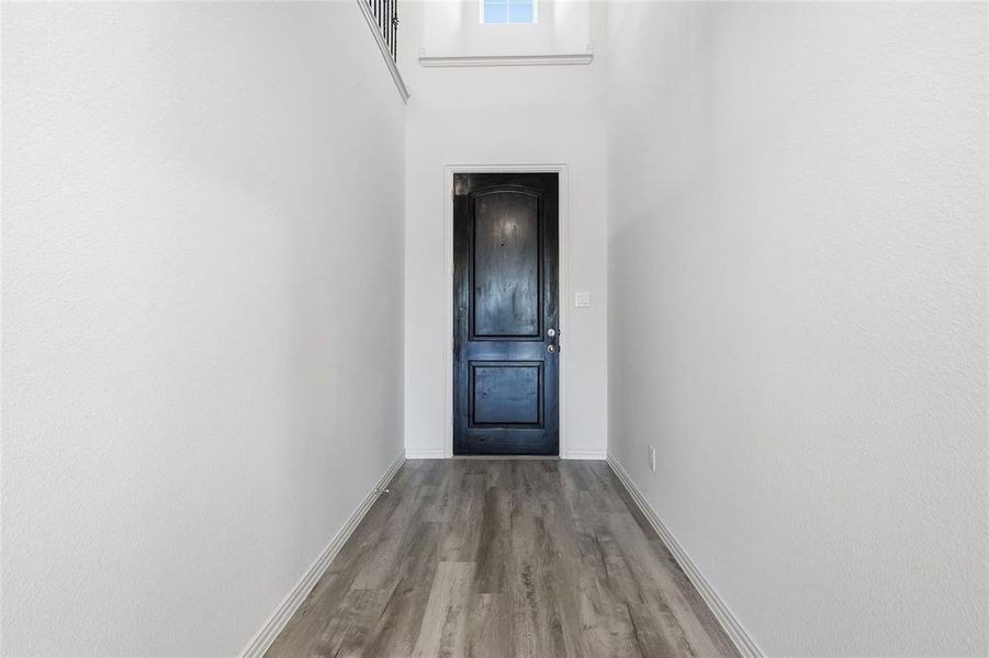 Entryway with wood finished floors and a high ceiling Entryway with wood finished floors and a high ceiling