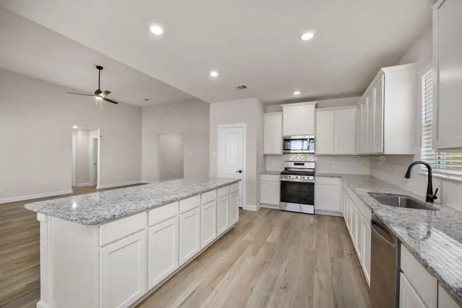 The kitchen comes equipped with Whirlpool kitchen appliances, granite countertops, and a gorgeous kitchen island.