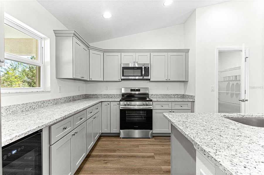 KITCHEN ISLAND HAS A LARGE DOUBLE BOWL SINK IWTH DISHWASHER AND PLENTY OF CABINETS