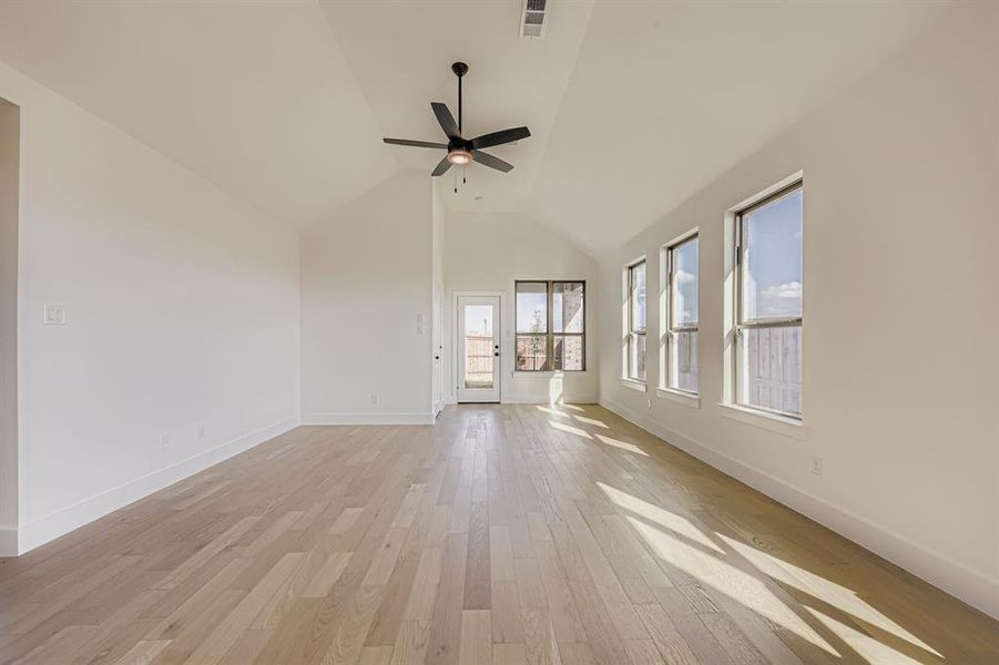Spare room featuring light wood-style flooring, a ceiling fan, and high vaulted ceiling Spare room featuring light wood-style flooring, a ceiling fan, and high vaulted ceiling