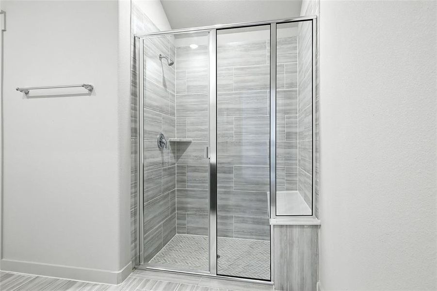 Bathroom featuring a stall shower and baseboards Bathroom featuring a stall shower and baseboards