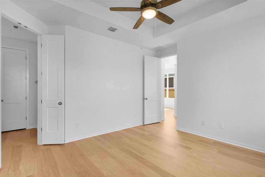 Unfurnished bedroom with light wood-type flooring and a ceiling fan Unfurnished bedroom with light wood-type flooring and a ceiling fan