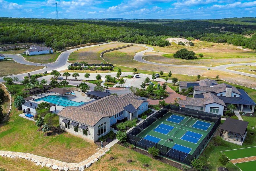 Aerial view highlights the expansive neighborhood amenities including a swimming pool, tennis courts, and surrounding greenery. Aerial view highlights the expansive neighborhood amenities including a swimming pool, tennis courts, and surrounding greenery.