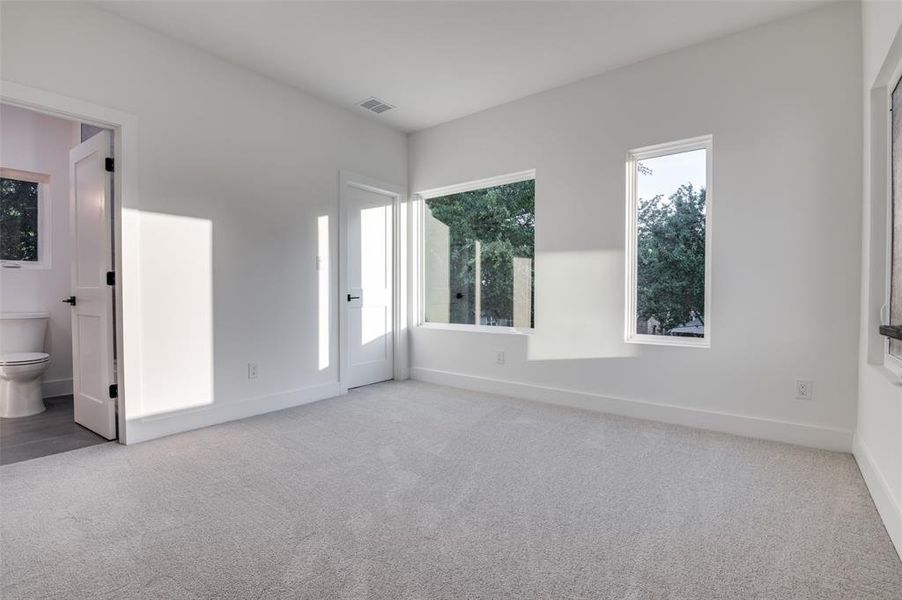 Unfurnished bedroom featuring carpet floors and connected bathroom Unfurnished bedroom featuring carpet floors and connected bathroom