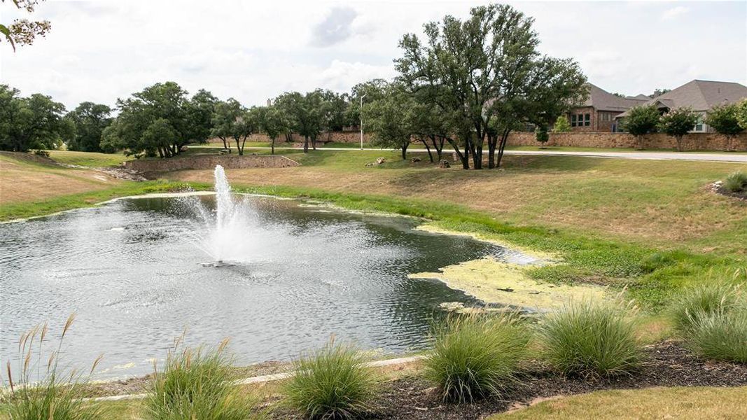 View of property's community with a yard and a water view