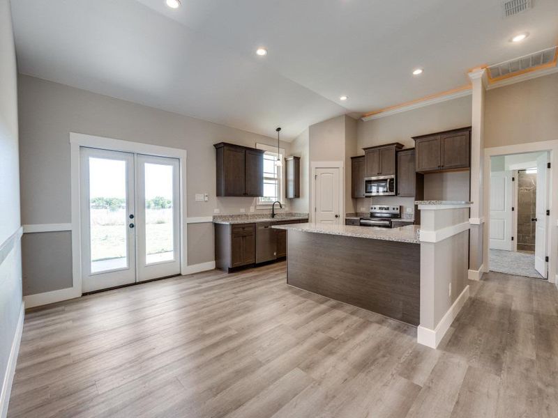 Kitchen with french doors, dark brown cabinets, stainless steel appliances, and visible vents