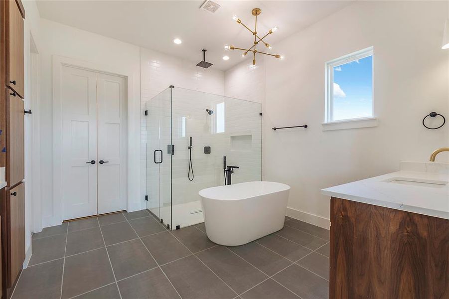 Freestanding soaking tub with a walk-in glass shower, white subway tile surround, and matte black fixtures Freestanding soaking tub with a walk-in glass shower, white subway tile surround, and matte black fixtures