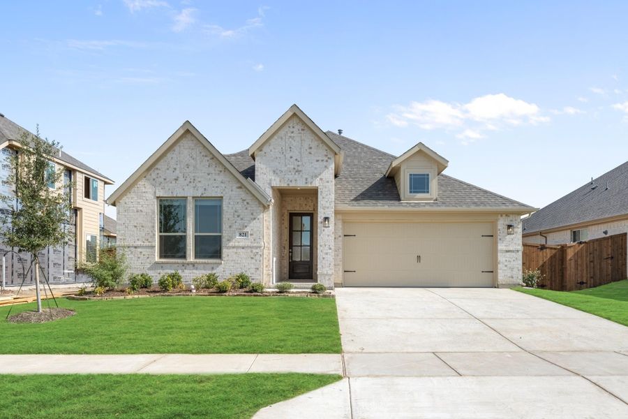 Single-story brick home with two-car garage, pitched roof, and green front lawn Single-story brick home with two-car garage, pitched roof, and green front lawn