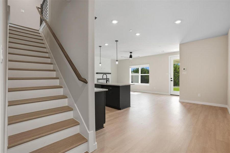 Staircase featuring recessed lighting and wood finished floors Staircase featuring recessed lighting and wood finished floors