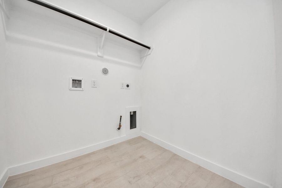 A perfect blend of functionality and comfort. Capture the essence of easy living with a first-floor laundry room, thoughtfully equipped with shelving for effortless organization. Both electric and gas connections available. Sample photo of completed home with similar floor plan. Actual colors and selections may vary.