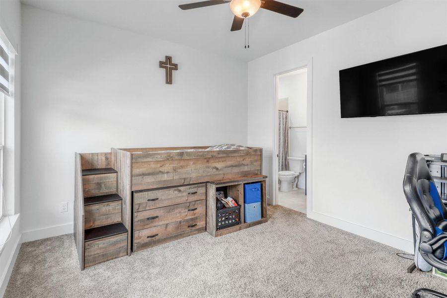 Fourth bedroom upstairs has plush carpeting, ceiling fan, large walk-in closet, and its own full bathroom.