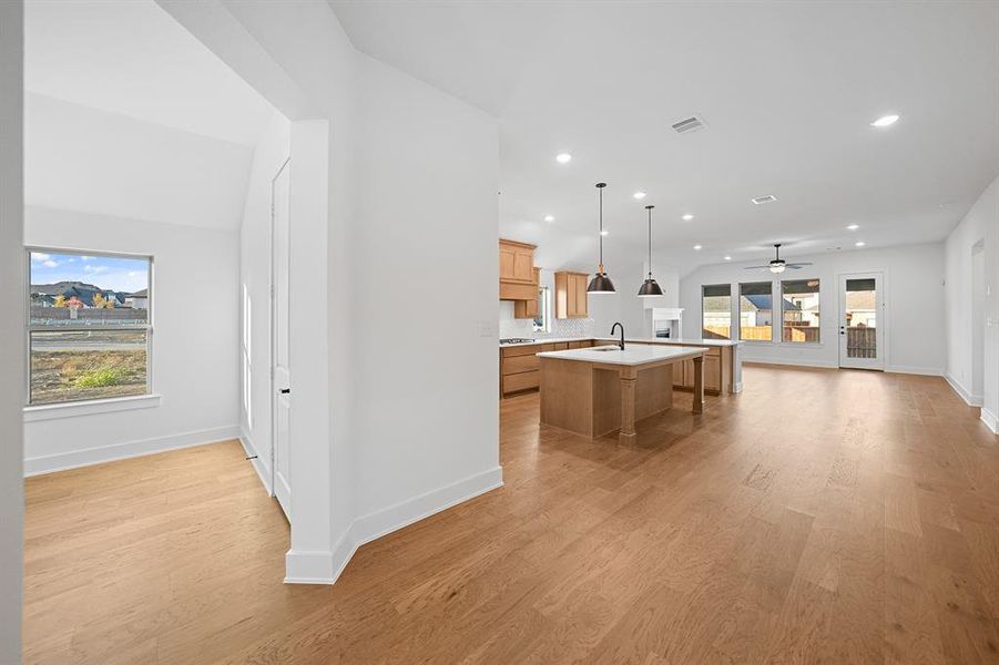 Kitchen with ceiling fan, a kitchen island with sink, open floor plan, a kitchen breakfast bar, and pendant lighting Kitchen with ceiling fan, a kitchen island with sink, open floor plan, a kitchen breakfast bar, and pendant lighting