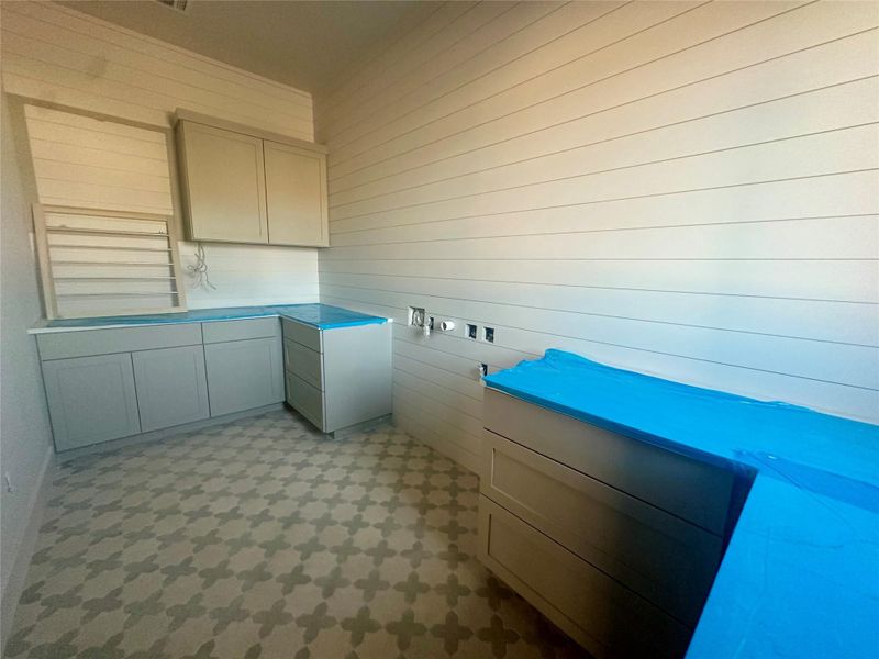 Laundry room with light floors and wooden walls Laundry room with light floors and wooden walls
