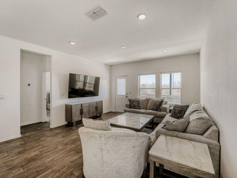 Living area featuring dark wood-style flooring and recessed lighting