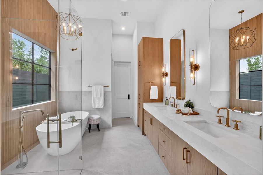 An inviting bathroom offers a freestanding tub, dual vanities, and a modern aesthetic.