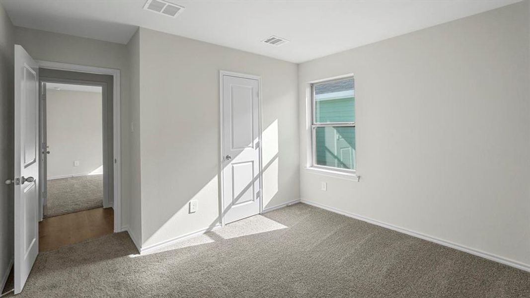 Unfurnished bedroom with light carpet and baseboards