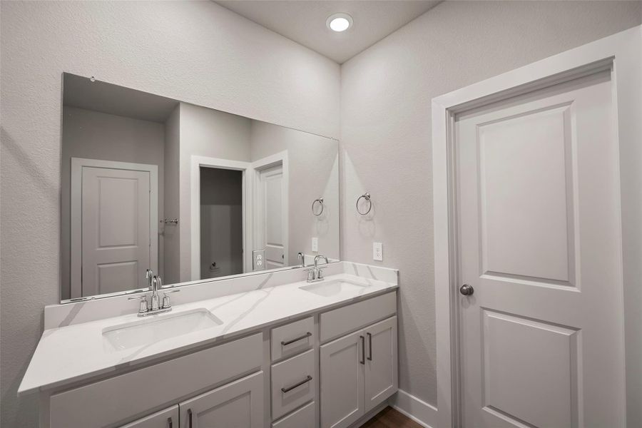 Elegant ensuite with dual vanities and separate glass shower.