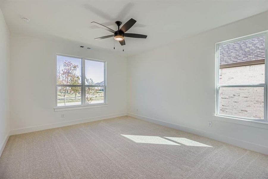 Unfurnished room with light carpet and ceiling fan Unfurnished room with light carpet and ceiling fan