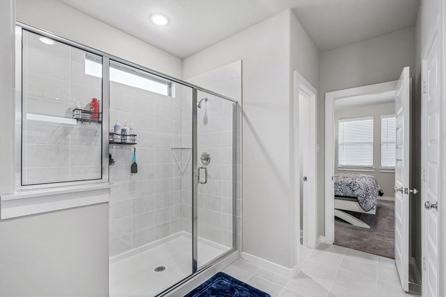 Bathroom with a healthy amount of sunlight, tile flooring, and a shower with shower door