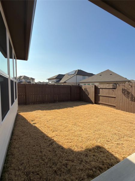 Spacious backyard with a wood privacy fence and a concrete patio