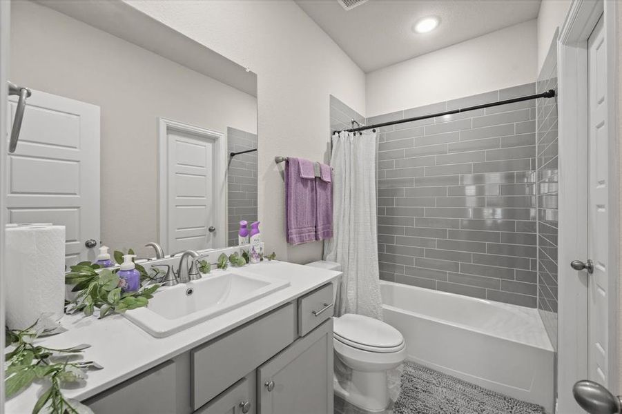 Full bathroom featuring toilet, shower / tub combo with curtain, and vanity