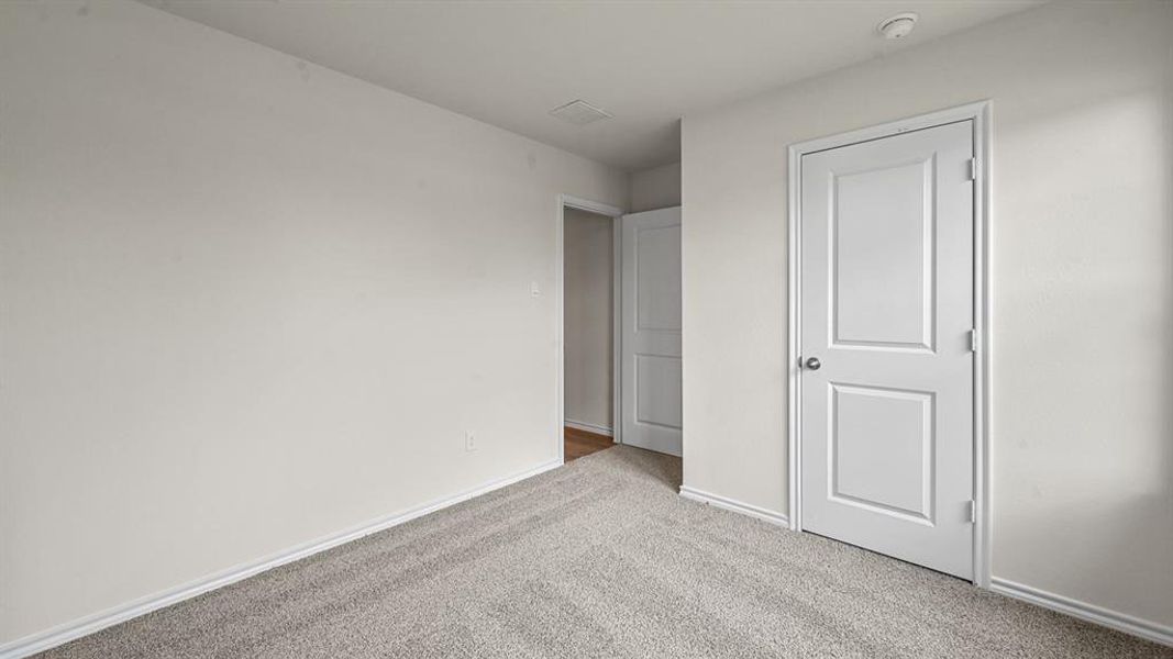 Unfurnished bedroom featuring light carpet and baseboards