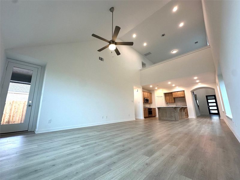 Large open family room with soaring 20ft ceiling offers seamless entertaining and extended back patio.
