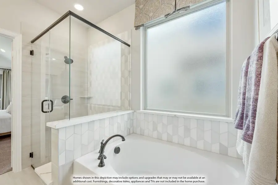 Bathroom with soaking tub, glass-enclosed walk-in shower, white geometric tile, and frosted window Bathroom with soaking tub, glass-enclosed walk-in shower, white geometric tile, and frosted window