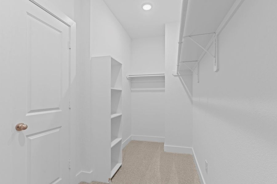 The primary suite’s spacious walk-in closet includes custom shelving and hanging storage—conveniently located just off the bath for seamless morning routines. **Image Representative of Plan Only and May Vary as Built**. The primary suite’s spacious walk-in closet includes custom shelving and hanging storage—conveniently located just off the bath for seamless morning routines. **Image Representative of Plan Only and May Vary as Built**.