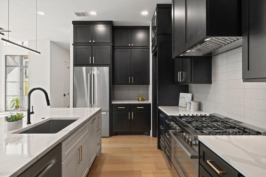 The chef’s kitchen is a true showpiece with professional-grade appliances, custom cabinetry, quartz waterfall island and butler’s pantry.