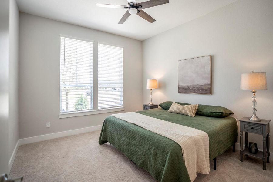 Bright windows and a soothing neutral palette give this first-floor guest suite a welcoming feel, while its large walk-in closet and private full bathroom make overnight stays feel especially comfortable.