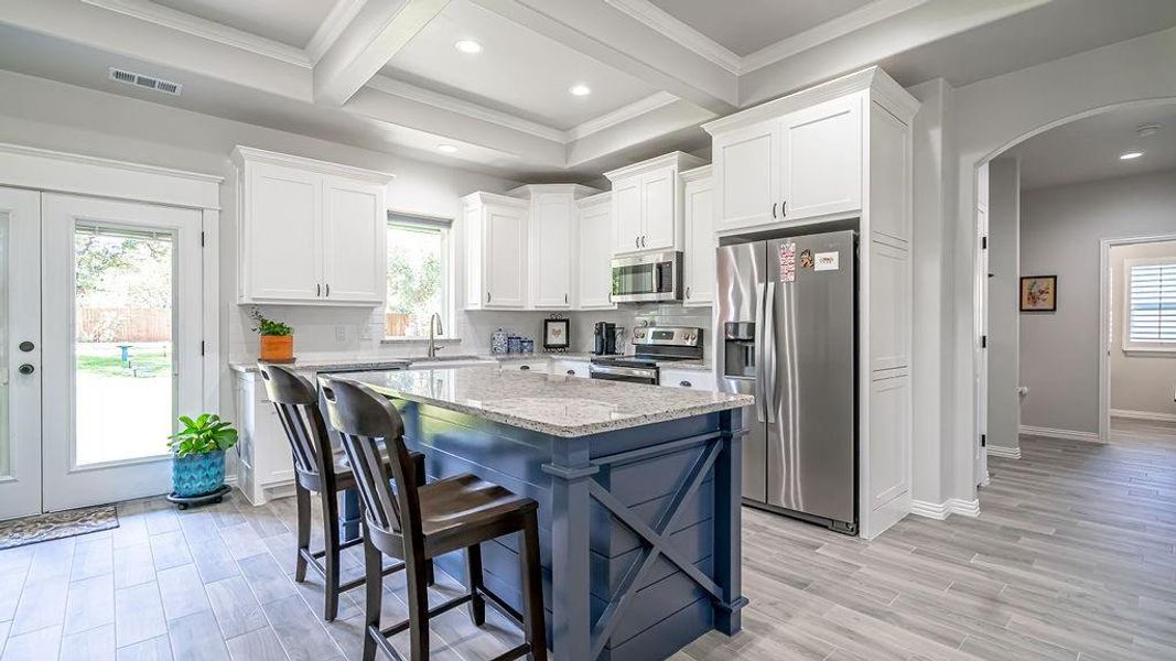 Kitchen with white cabinets, stainless steel appliances, plenty of natural light, and a center island