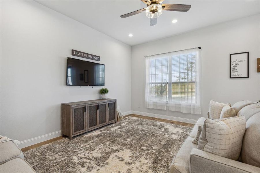 Living room with wood-type flooring and ceiling fan