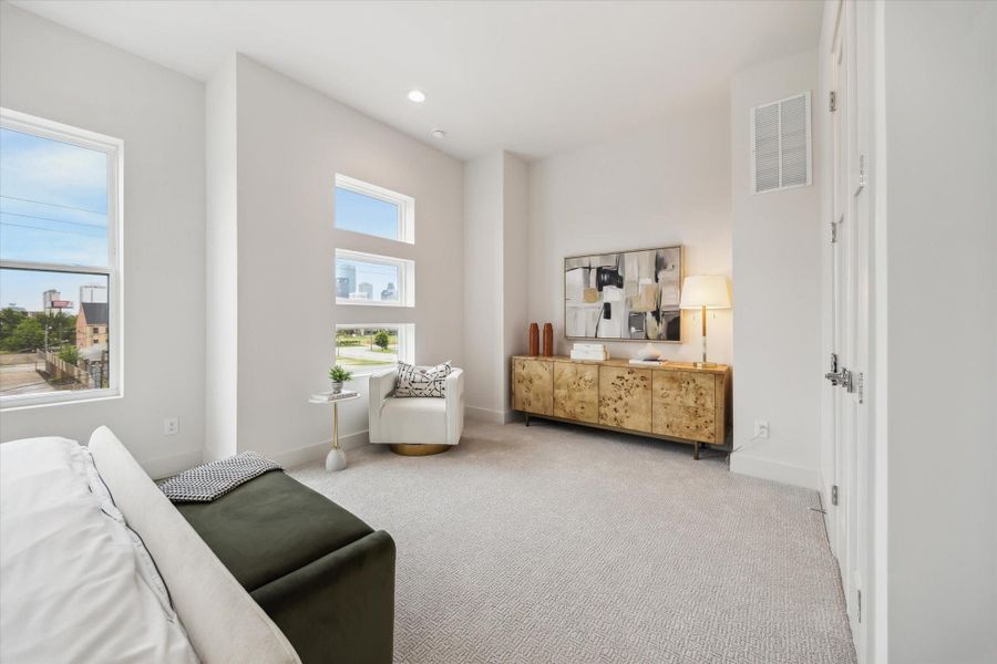 This bright, modern room features large windows with city views, a cozy seating area, and a stylish wooden sideboard. Perfect for relaxing or entertaining.