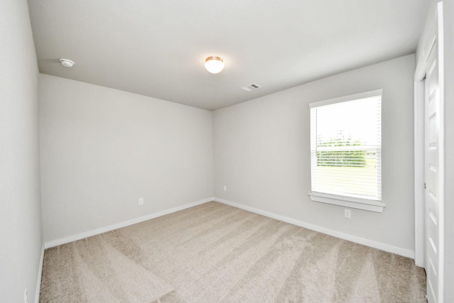 Secondary bedroom features plush carpeting, large windows that let in plenty of natural light, bright paint, and spacious closets. Sample photo of completed home with similar floor plan. Actual colors and selections may vary. Secondary bedroom features plush carpeting, large windows that let in plenty of natural light, bright paint, and spacious closets. Sample photo of completed home with similar floor plan. Actual colors and selections may vary.