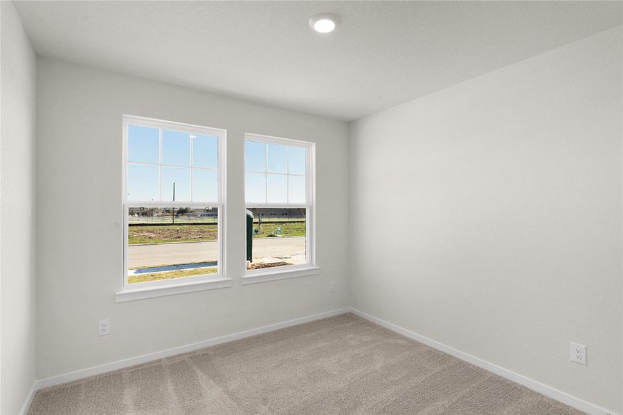 Empty room featuring light colored carpet and baseboards