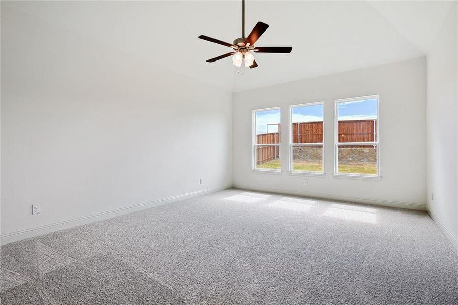 Empty room with carpet, ceiling fan, and lofted ceiling