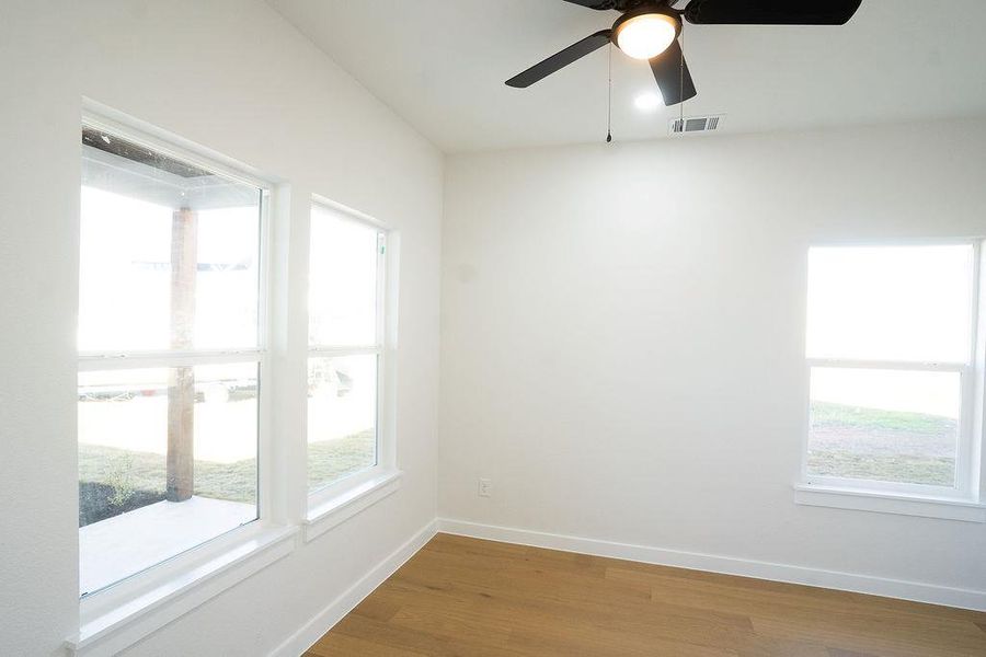 Unfurnished room with dark wood-style floors and ceiling fan