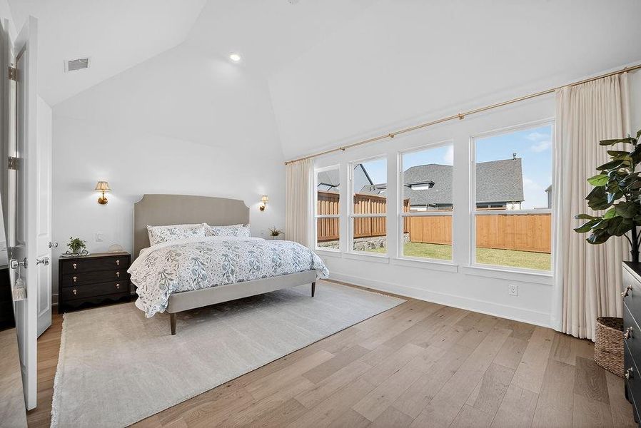 Bedroom with light wood-type flooring, high vaulted ceiling, and recessed lighting Bedroom with light wood-type flooring, high vaulted ceiling, and recessed lighting