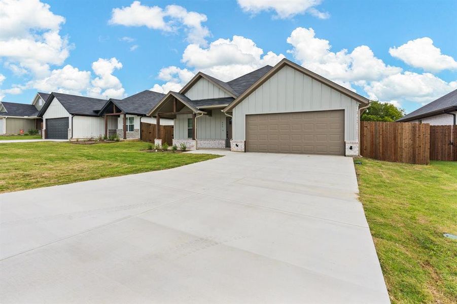 View of front of home featuring a front yard and a garage