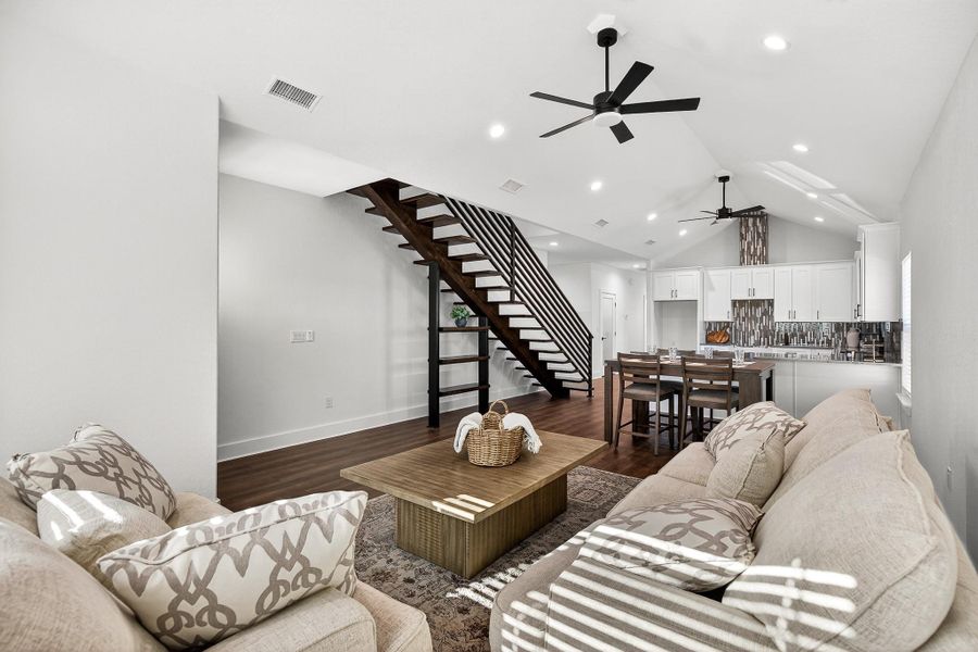 Living area featuring stairs, dark wood finished floors, vaulted ceiling, recessed lighting, and ceiling fan Living area featuring stairs, dark wood finished floors, vaulted ceiling, recessed lighting, and ceiling fan