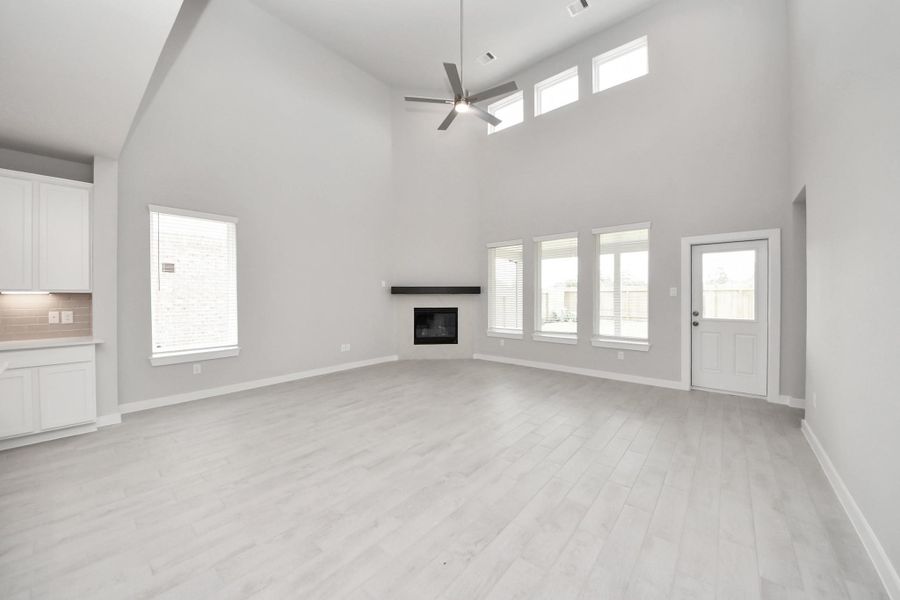 Gather the family and guests together in your lovely living room! Featuring soaring high ceilings, recessed lighting, ceiling fan, custom paint, gorgeous floors, and large windows that provide plenty of natural lighting throughout the day. Sample photo of completed home with similar floor plan. Actual colors and selections may vary. Gather the family and guests together in your lovely living room! Featuring soaring high ceilings, recessed lighting, ceiling fan, custom paint, gorgeous floors, and large windows that provide plenty of natural lighting throughout the day. Sample photo of completed home with similar floor plan. Actual colors and selections may vary.