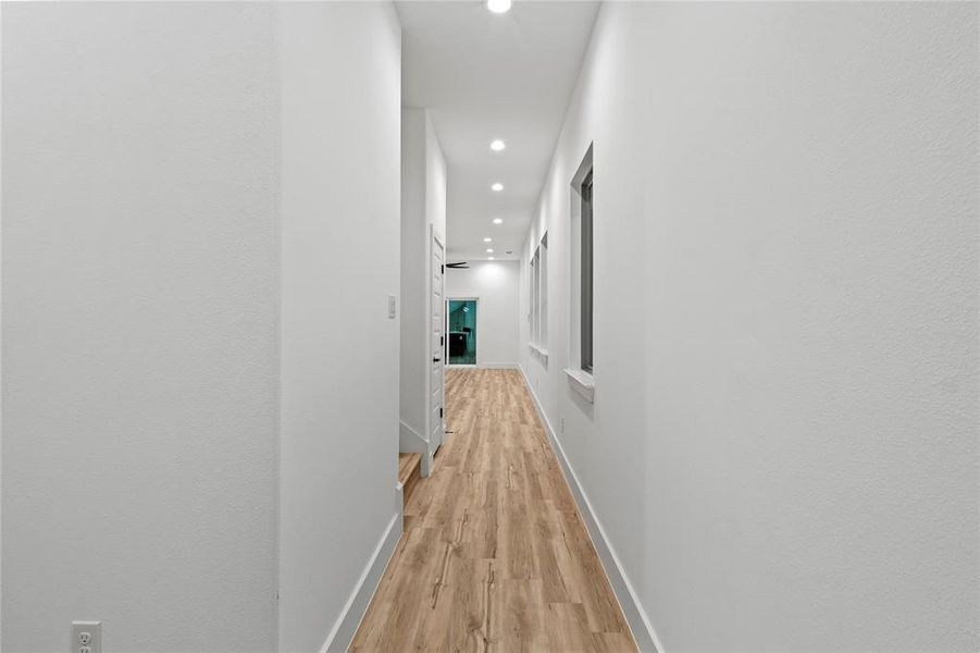 Hallway with light hardwood / wood-style flooring