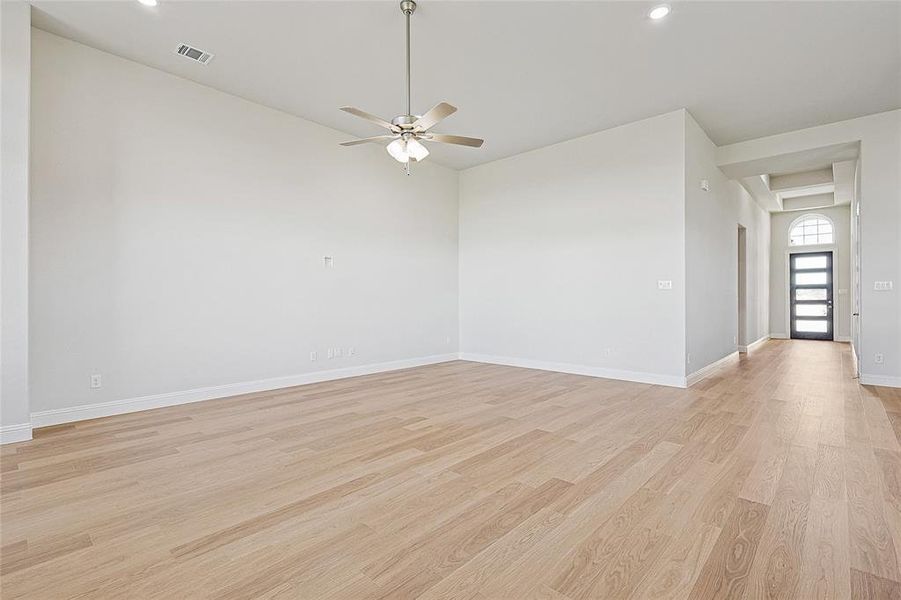 Empty room with ceiling fan and light wood-type flooring