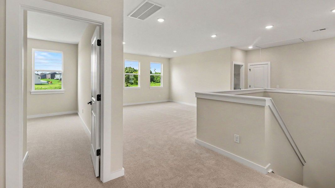 View from the second floor landing showing the loft area and a secondary bedroom