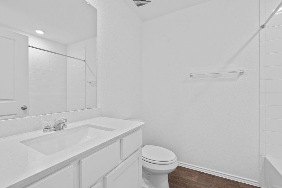 Bathroom featuring dark wood finished floors, vanity, and bathtub / shower combination Bathroom featuring dark wood finished floors, vanity, and bathtub / shower combination